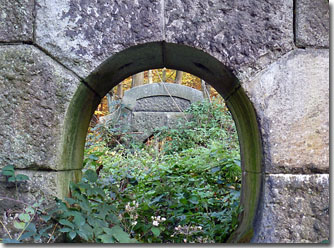 Bild: eine Mauer mit Durchblick auf ein Objekt